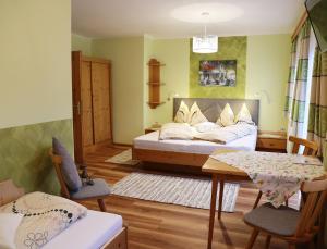 una camera con letto, tavolo e sedie di Haufhof-Pension am Bauernhof, Haus im Ennstal bei Schladming a Haus im Ennstal