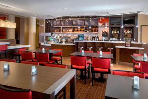 un restaurante con mesas y sillas rojas y un bar en Courtyard by Marriott Paramus, en Paramus