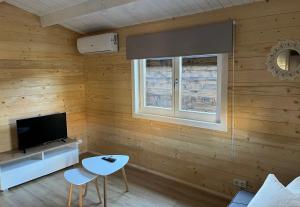 uma sala de estar com paredes de madeira, uma televisão e uma mesa em Casas de A Uriceira em Cangas