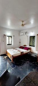 a bedroom with a large bed on a marble floor at Green House Stay in Mandrem