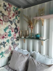 a bedroom with a floral wall with a couch and flowers at La cabane du berger du parc national ESM in Froid-Chapelle