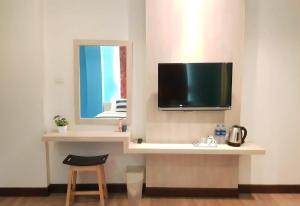 Habitación con mesa y TV en la pared. en iCheck inn Chill Patong, en Patong Beach