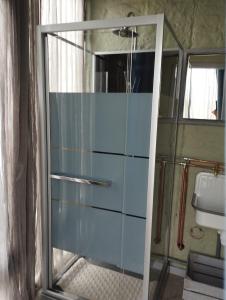 eine Glastür im Bad mit Waschbecken in der Unterkunft La cabane du berger du parc national ESM in Froidchapelle