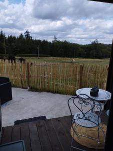 d'une terrasse avec une table et une clôture. dans l'établissement La cabane du berger du parc national ESM, à Froidchapelle
