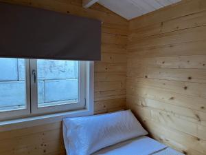 um quarto com paredes de madeira, uma janela e uma cama em Casas de A Uriceira em Cangas