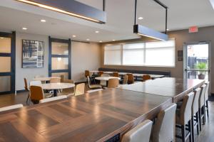 uma sala de jantar com uma grande mesa de madeira e cadeiras em Residence Inn Visalia em Visalia