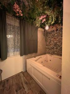 La salle de bains est pourvue d'une baignoire et de fleurs au plafond. dans l'établissement A due passi da, à Formia