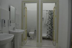a white bathroom with a sink and a toilet at Hostel DANEXAN APA in Nukus
