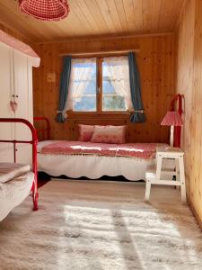 Schlafzimmer mit einem Bett und einem Fenster in der Unterkunft Charming Chalet with mountain view near Arosa for 6 People house exclusive use in Langwies