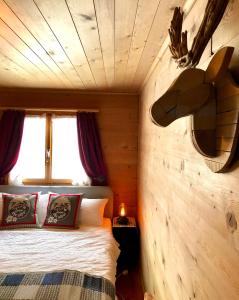 1 dormitorio con 1 cama en una habitación de madera en Charming Chalet with mountain view near Arosa for 6 People house exclusive use, en Langwies