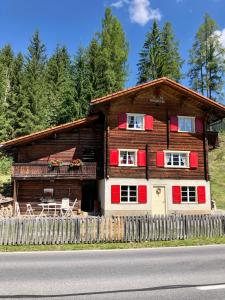 ein Holzhaus mit einem Zaun davor in der Unterkunft Charming Chalet with mountain view near Arosa for 6 People house exclusive use in Langwies