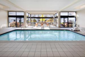 a large swimming pool in a building with windows at Courtyard Detroit Southfield in Southfield