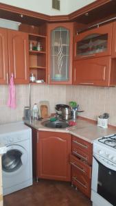 a kitchen with red cabinets and a stove top oven at Колливинг на Республике (золотой квадрат) in Astana
