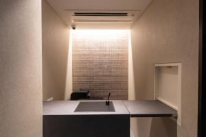 eine Küche mit einem Waschbecken und einem Fenster in der Unterkunft Oyado Kawaramachi Gojo（御宿 河原町五条） in Kyoto
