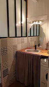 uma casa de banho com um lavatório e um espelho em Maison Candide 3 chambres 1 mezzanine em Capbreton