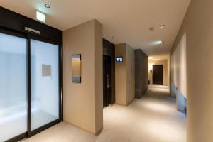 a hallway of a building with glass doors at Oyado Kawaramachi Gojo（御宿 河原町五条） in Kyoto