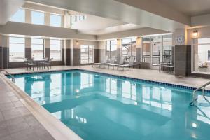 ein großer Pool mit blauem Wasser in einem Gebäude in der Unterkunft Residence Inn by Marriott Des Moines Ankeny in Ankeny