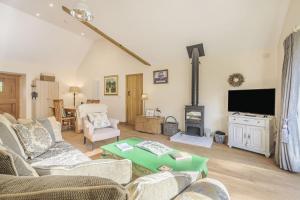 a living room with a couch and a fireplace at Old Farm Stables in Yeovil
