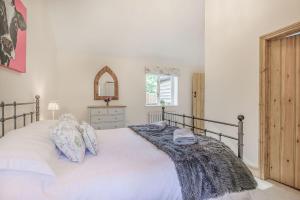a bedroom with a large white bed and a window at Old Farm Stables in Yeovil