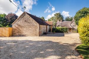 un vecchio edificio di mattoni con una croce sul davanti di Old Farm Stables a Yeovil