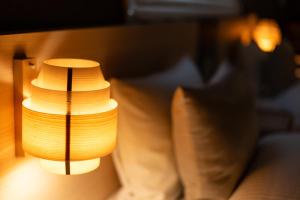 a lamp that is sitting next to a couch at Oyado Kawaramachi Gojo（御宿 河原町五条） in Kyoto