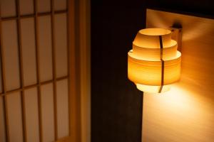 a light hanging on a wall next to a door at Oyado Kawaramachi Gojo（御宿 河原町五条） in Kyoto