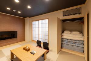 a room with a table and a bunk bed at Oyado Kawaramachi Gojo（御宿 河原町五条） in Kyoto