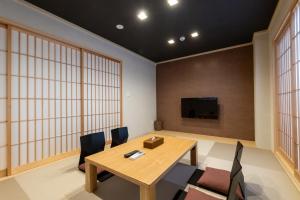 a conference room with a wooden table and chairs at Oyado Kawaramachi Gojo（御宿 河原町五条） in Kyoto