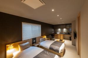 a hotel room with two beds and a kitchen at Oyado Kawaramachi Gojo（御宿 河原町五条） in Kyoto