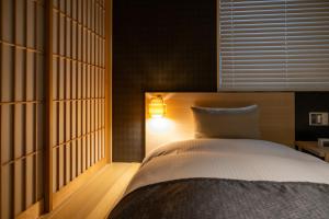 a bedroom with a bed with a light on it at Oyado Kawaramachi Gojo（御宿 河原町五条） in Kyoto
