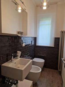 a bathroom with a sink and a toilet and a mirror at Villetta in Massa