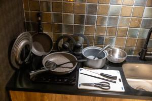 a kitchen counter with pots and pans on a stove at Oyado Kawaramachi Gojo（御宿 河原町五条） in Kyoto