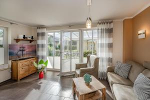 a living room with a couch and a tv at Haus Ines in Korswandt
