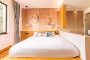 1 dormitorio con 1 cama blanca grande en una habitación en MK Inn en Hangzhou