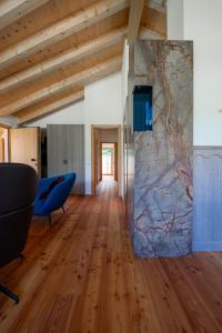 a room with a stone wall and a blue chair at Appartamento GreenWood in Vodo Cadore