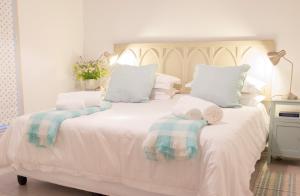 a bedroom with a white bed with towels on it at The River Bend Cottages in Graaff-Reinet