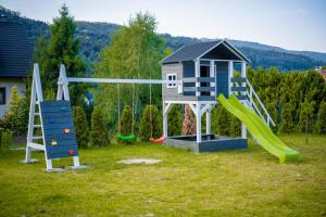 un parque infantil con una casa de juegos y un tobogán en Nad Lipami en Szczyrk