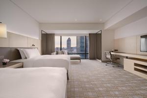 a hotel room with two beds and a desk at Taipei Marriott Hotel in Taipei