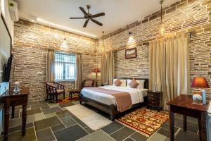a bedroom with a bed and a brick wall at Moonstone, Bhopal, amã Stays & Trails in Shamsgarh