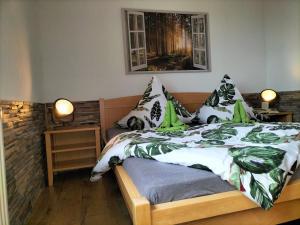 a bedroom with a bed with green and white sheets and pillows at Ferienwohnung Emilie in Masserberg