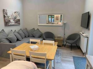 a living room with a couch and a table at Hedgehog Cottage in Bury Saint Edmunds