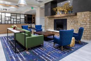 a lobby with a fireplace and a green couch and chairs at Residence Inn Denver City Center in Denver