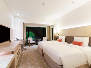台北市にある台北マリオットホテルのベッド2台、薄型テレビが備わるホテルルームです。