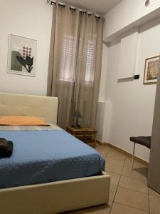 una camera con un letto e una sedia e una finestra di Romagna Apartments a Massa Lombarda