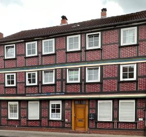 a brick building with a brown door and white windows at Apartment for rent3 in Celle