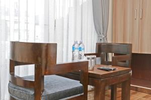 加德滿都的住宿－Hotel Royal Emperor，2瓶带2把椅子的桌子上的水