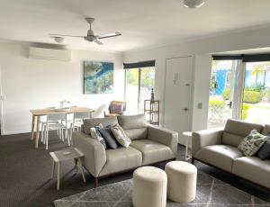 a living room with a couch and a table at 2 Bedroom Villa In Tropical Resort in Noosaville