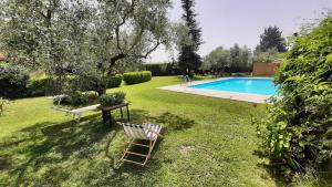 a yard with a chair next to a swimming pool at Casale Battaglini in Castelnuovo Cilento