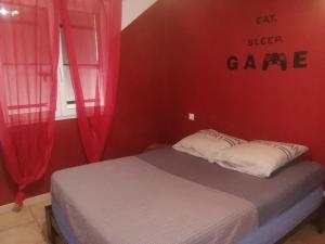 a bedroom with a bed with red walls and red curtains at The happy house in Le Martinet