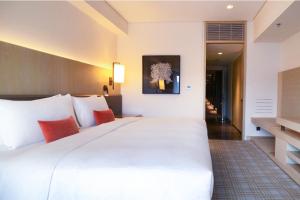 台北市にある台北マリオットホテルのベッドルーム(オレンジ色の枕が付いた大きな白いベッド付)